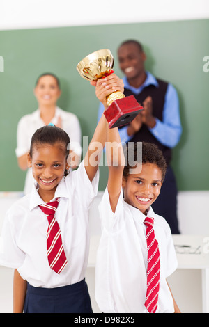 Deux élèves de l'école élémentaire tient un trophée en classe Banque D'Images