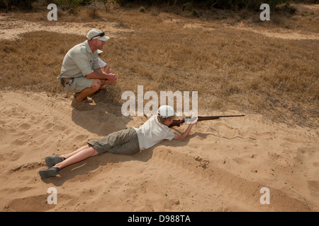 Un garçon apprendre à tirer avec une carabine à Phinda Game Reserve, Afrique du Sud Banque D'Images