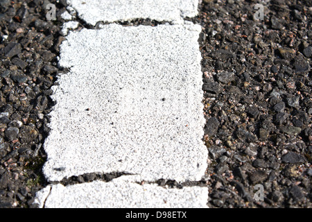 Détail de la ligne blanche peinte sur road montrant des fissures et la texture de surface de la route d'asphalte Banque D'Images