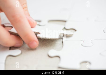 Main de petite fille 3-4 ans mise en forme de pièce de puzzle blanc Banque D'Images