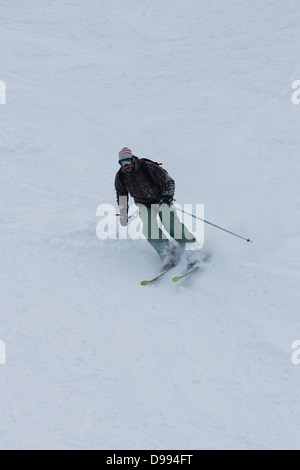 Skieur de montagne en descendant du flanc d'une montagne Banque D'Images