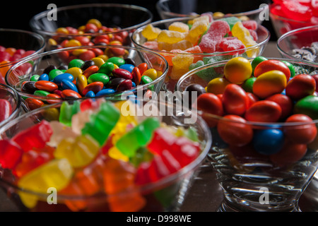 Bonbons mixtes colorés dans de petits bols en verre clair Banque D'Images