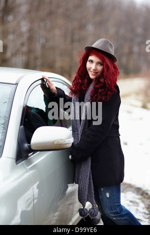 Cute girl readhead en sortant de sa voiture, extérieur portrait Banque D'Images