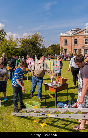 Un garçon jouant l'échelle et à un jeu de pouf fête du village à Sotterley Hall à Sotterley , Suffolk , Angleterre , Angleterre , Royaume-Uni Banque D'Images