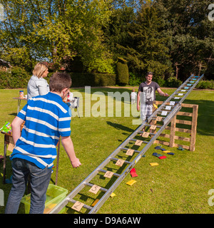 Un garçon jouant l'échelle et à un jeu de pouf fête du village à Sotterley Hall à Sotterley , Suffolk , Angleterre , Angleterre , Royaume-Uni Banque D'Images