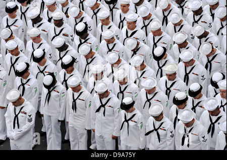 Les marins de l'US Navy affecté à l'assaut amphibie USS Makin Island baissent la tête pour l'appel au cours d'une cérémonie de passation de commandement tenue sur le pont d'envol du navire le 14 juin 2013 à San Diego, CA. Banque D'Images