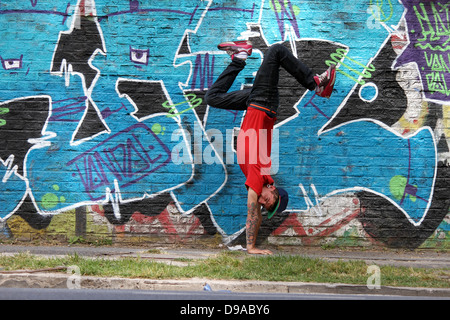 Un spectacle d'HipHop danseur en face d'un mur de graffiti. Banque D'Images