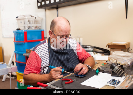 Man travaillant avec fer à souder en atelier Banque D'Images