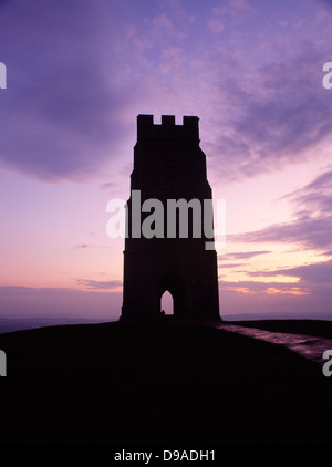 La tour en ruine de St Michael's Chapel sur haut de Tor de Glastonbury, Somerset, vu comme une silhouette contre un ciel de coucher du soleil. Silhouette encapuchonnée dans archway. Banque D'Images