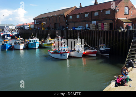 Les bateaux de pêche lié aux côtés du quai de poisson dans le port de Scarborough auprès des vacanciers à l'avant-plan de pêche au crabe Banque D'Images