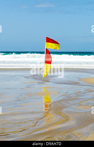 Coffre-fort rouge et jaune zone de baignade, drapeau, plage de Fistral, Newquay, Cornwall, Angleterre lifeguarded salon scène surf britannique Banque D'Images