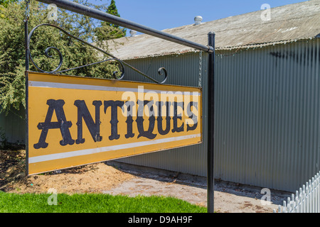 Un signe de métal avec le lettrage 'Antiquités' en face d'une vieille maison qui sert comme un magasin d'antiquités à Los Alamos, en Californie. Banque D'Images