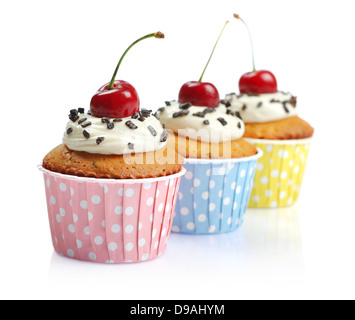 Cupcakes avec de la crème fouettée et de cerises isolé sur fond blanc Banque D'Images