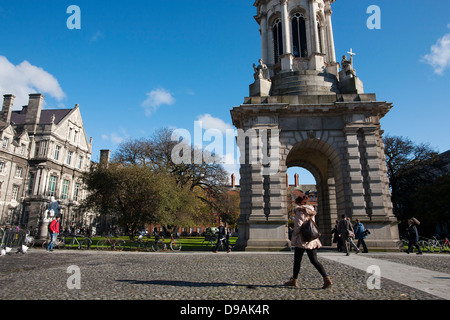 Une femme marche en face de l'hôtel Campanile de la place du Parlement dans les motifs de Trinity College de Dublin, en République d'Irlande Banque D'Images