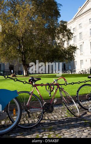 Des vélos et des vélos sont verrouillés et enchaîné à une clôture à l'intérieur des terres de Trinity College de Dublin, en République d'Irlande Banque D'Images