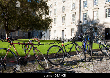 Des vélos et des vélos sont verrouillés et enchaîné à une clôture à l'intérieur des terres de Trinity College de Dublin, en République d'Irlande Banque D'Images