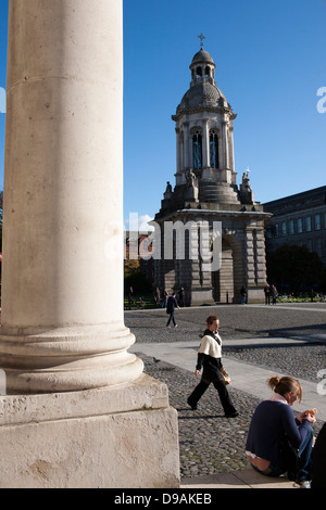 Une femme marche en face de l'hôtel Campanile de la place du Parlement dans les motifs de Trinity College de Dublin, en République d'Irlande Banque D'Images