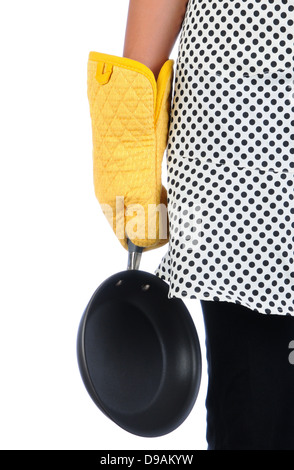 Libre d'une femme tenant une poêle à ses côtés. Femme porte un tablier à pois jaune et une mitaine. Banque D'Images