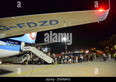 Les passagers d'Thomson Airways Boeing 737 la nuit, l'aéroport de Rhodes, Rhodes (Rodos), du Dodécanèse, sud de la mer Egée, Grèce Banque D'Images