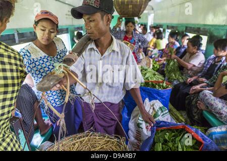 Yangon, Union du Myanmar. 15 Juin, 2013. Les vendeurs de marché prendre le train jusqu'à la circulaire de Yangon un marché en dehors de Yangon. La Circulaire de Yangon est le chemin de fer réseau ferroviaire suburbain local qui dessert la région métropolitaine de Yangon. Exploité par les chemins de fer, le Myanmar 45,9 kilomètres (28,5Â mi) 39-station système boucle relie des villes satellites et les banlieues de la ville. Le chemin de fer a environ 200 entraîneurs, s'exécute 20 fois et vend 100 000 à 150 000 billets par jour. La boucle, qui prend environ trois heures, est populaire pour les touristes de voir une section transversale de la vie à Yangon. Les trains à partir de 3:45 Banque D'Images