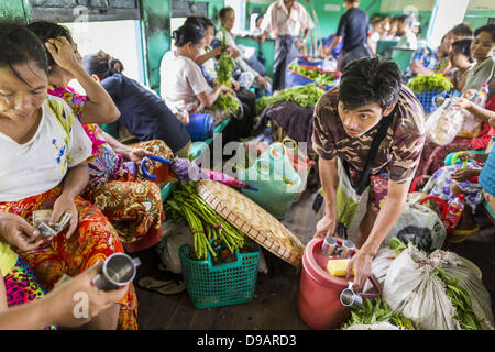 Yangon, Union du Myanmar. 15 Juin, 2013. Un vendeur d'eau vend des tasses d'eau pour les passagers sur le Train Circulaire de Yangon. Circulaire de Yangon fer est le réseau ferroviaire suburbain local qui dessert la région métropolitaine de Yangon. Exploité par les chemins de fer, le Myanmar 45,9 kilomètres (28,5Â mi) 39-station système boucle relie des villes satellites et les banlieues de la ville. Le chemin de fer a environ 200 entraîneurs, s'exécute 20 fois et vend 100 000 à 150 000 billets par jour. La boucle, qui prend environ trois heures, est populaire pour les touristes de voir une section transversale de la vie à Yangon. Les trains à partir de 3:45 am Banque D'Images