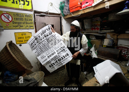 Yoel Krois, un Juif ultra-orthodoxe de Neturie Karta un groupe religieux qui se divise du judaïsme normatif possède une Pashkvil qui est une affiche d'annonce de communauté traditionnelle dans le quartier de Mea Shearim, une enclave ultra-orthodoxe à Jérusalem Ouest d'Israël Banque D'Images