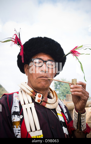 L'homme tribal Naga en tenue traditionnelle pipe, Hornbill Festival, Kohima, Nagaland, Inde Banque D'Images