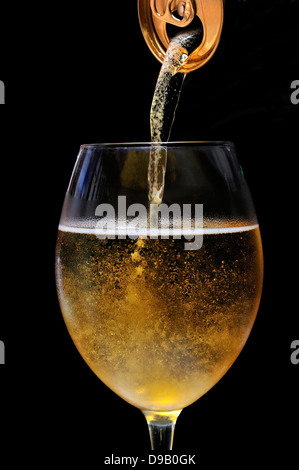 La bière versé d'un anonyme peut dans un grand verre Banque D'Images