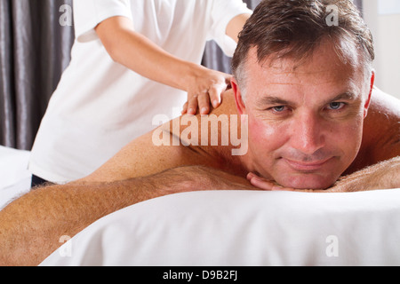 Homme mûr ayant massage au spa salon Banque D'Images