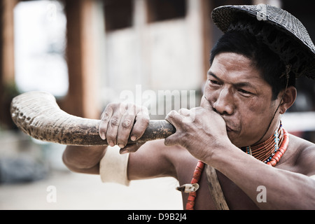 Tribu Naga soufflant cor de chasse au cours de l'assemblée statue d'Festival à Kisama, Kohima, Nagaland, Inde Banque D'Images