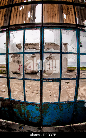 Panneaux de fenêtre cassés sur une grande porte d'un bâtiment d'usine délabrée. Banque D'Images