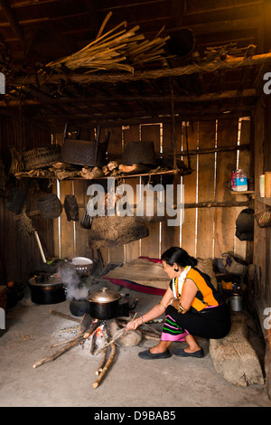 Tribeswoman Naga la cuisson dans une hutte, Kisama, Kohima, Nagaland, Inde Banque D'Images