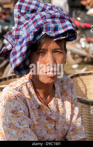 Vieille Femme portant une coiffe traditionnelle vérifié violet souriant à la caméra dans un marché Myanmar (Birmanie) Banque D'Images