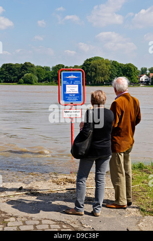 Couple de personnes âgées lecture que le Rhin ferry est hors service en raison de niveaux élevés de l'eau en juin 2013, Meerbusch, Allemagne. Banque D'Images