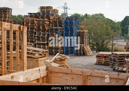 Stock des piles de palettes en bois dans une cour prête à dépecer et le recyclage en bois de chauffage ou le petit bois Banque D'Images