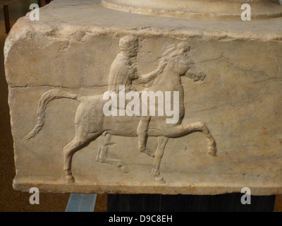 Base d'un dévouement en marbre. On trouve dans l'Agora athénienne. Base d'un dévouement pour les victoires dans le combat de cavalerie maquette concours. Trois côtés de celui-ci ont reliefs représentant un cavalier à cheval vers un trépied. L'inscription sur le quatrième côté fournit le nom des dedicators victorieux et également celle de l'Bryavis sculpteur qui a sculpté le monument. Il aura appuyé un trépied de bronze consacré par les vainqueurs. Milieu du 4e siècle avant J.-C.. Banque D'Images