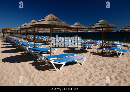 Transats et parasols sur une plage de sable fin de l'Algarve Banque D'Images