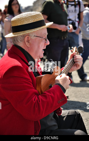 Un artiste de rue joue un ukulele sur la rue à l'extrémité ouest festival, Byres Road, Glasgow, Scotland, UK Banque D'Images