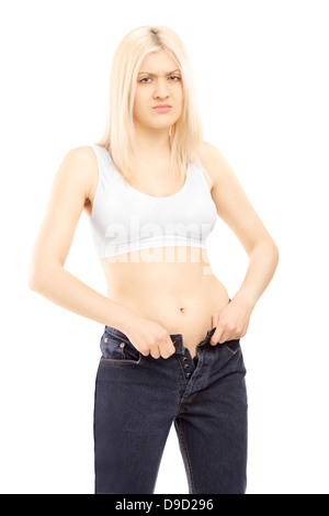 Femme essayant de mettre sur vieille paire de jeans Banque D'Images