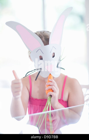 Fille en costume de lapin carotte manger Banque D'Images