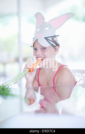 Fille en costume de lapin carotte manger Banque D'Images