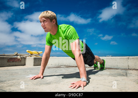 Jeune homme faisant des pompes sans on pier Banque D'Images