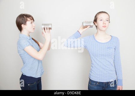 Deux filles avec des boîtes de conserve Banque D'Images