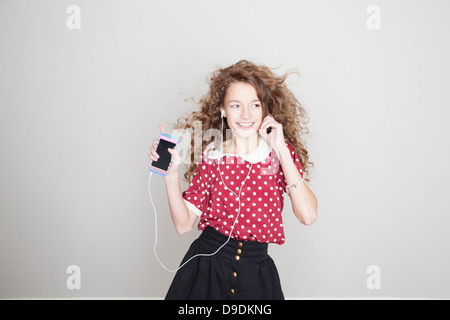 Girl wearing headphones, danse et holding mp3 player Banque D'Images