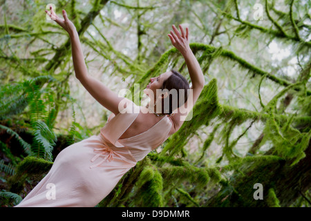 Young woman dancing in forest Banque D'Images