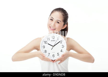 Mode Jeune femme tenant clocks Banque D'Images