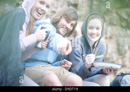 Jeune groupe de personnes boire et manger à l'extérieur Banque D'Images