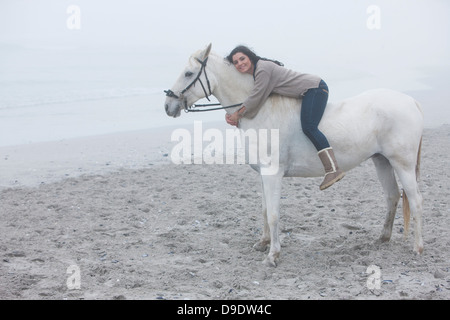 Woman riding horse on beach Banque D'Images