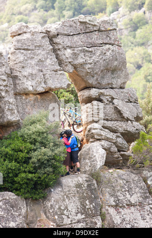 Mountain Biking couple kissing on rock formation Banque D'Images