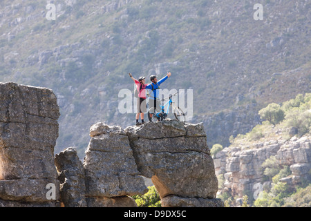 Mountain Biking couple celebrating on rock formation Banque D'Images